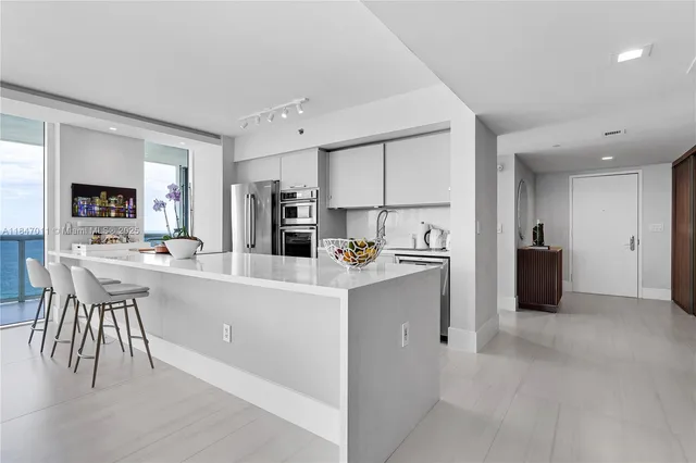 a kitchen with kitchen island a sink and a refrigerator