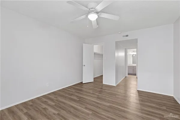 a view of an empty room with wooden floor