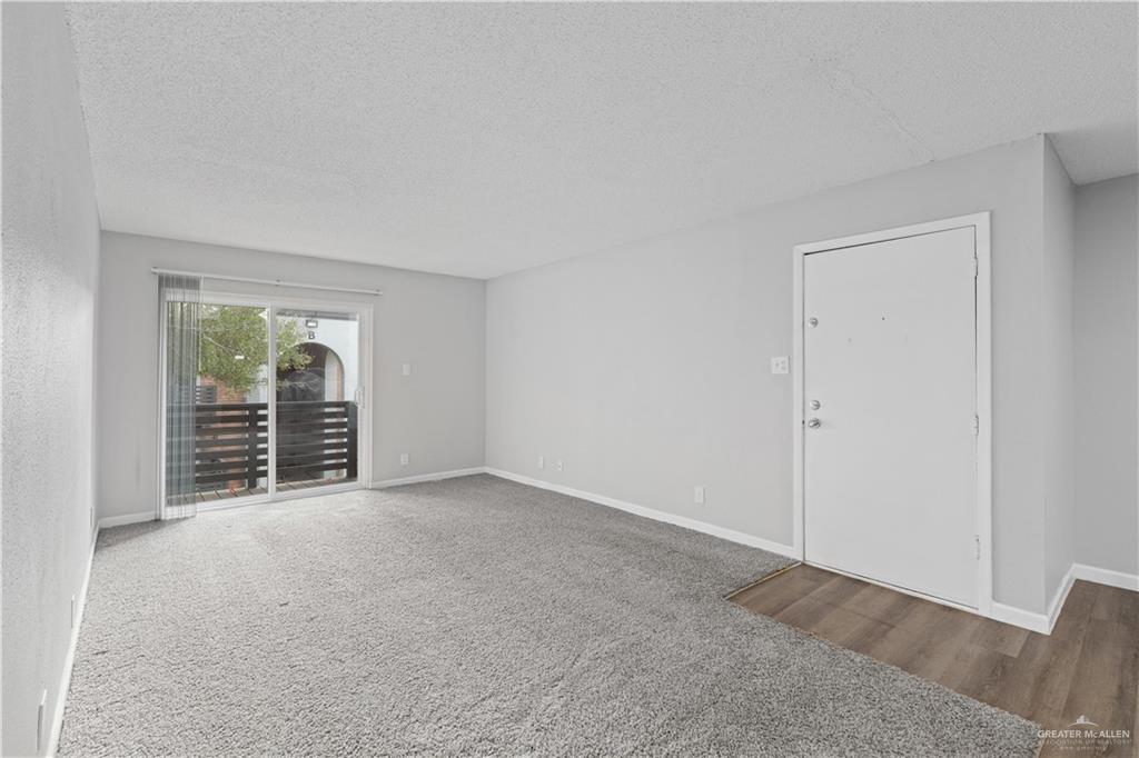 2425 Barnard Road, Unit UJNIT 1A Brownsville, TX 78520 - Photo 3 of 16 Empty room with a textured ceiling, baseboards, and wood finished floors