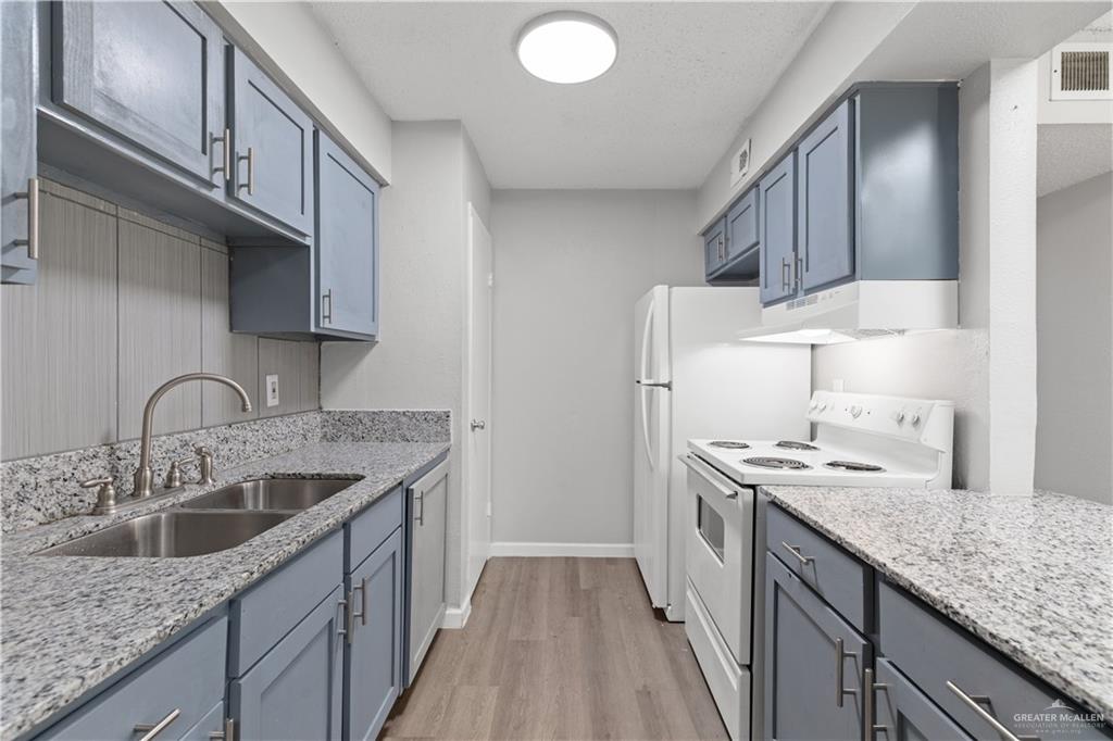 2425 Barnard Road, Unit UJNIT 1A Brownsville, TX 78520 - Photo 6 of 16 Kitchen featuring under cabinet range hood, visible vents, a sink, white electric range oven, and light wood-style floors