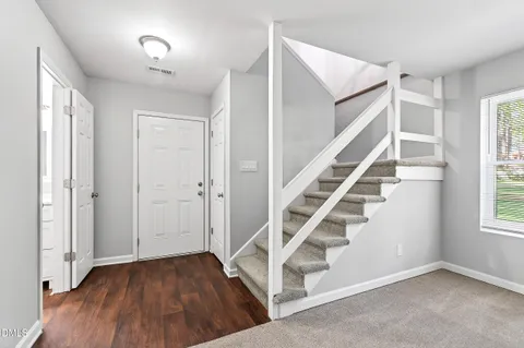 a kitchen with granite countertop stainless steel appliances a refrigerator cabinets and wooden floor