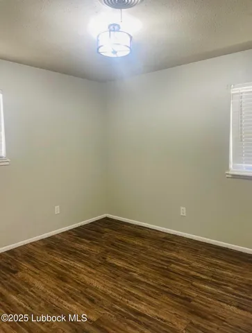 en empty room with wooden floor and window