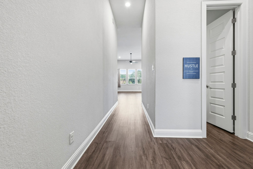 2032 Base Burner Path Leander, TX 78641 - Photo 19 of 34 Hallway featuring wood-finish flooring, light grey walls, and white baseboards