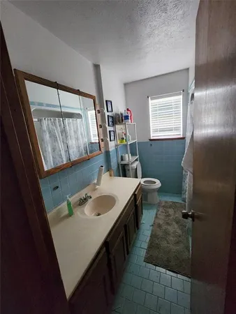 a bathroom with a sink a toilet and a mirror