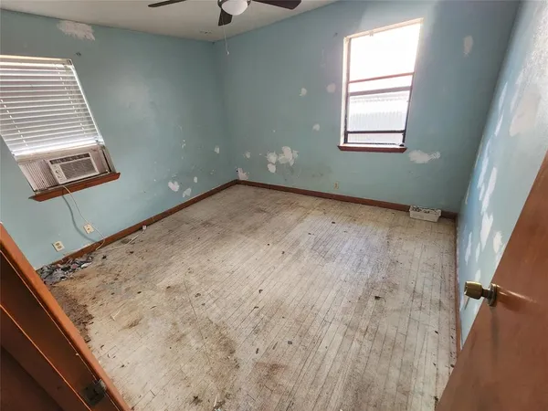 a view of a room with wooden floor and windows