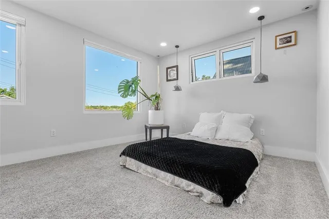 a bedroom with a bed lamp and a potted plant