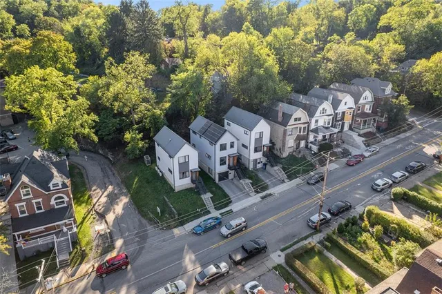 an aerial view of multiple houses with a street
