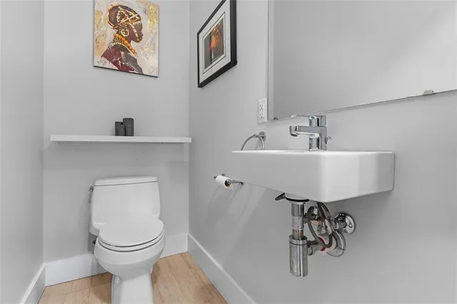 a bathroom with a toilet a sink and mirror