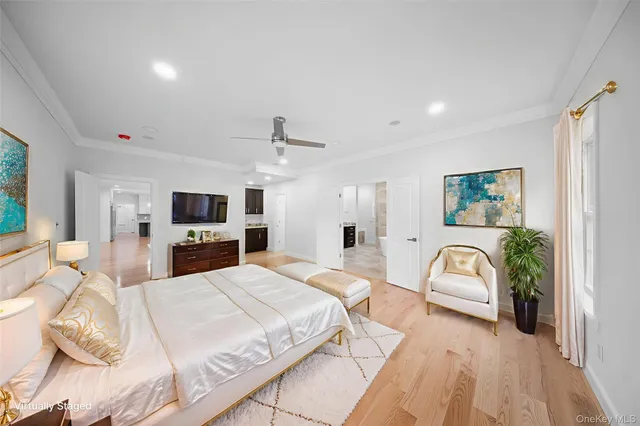 a large bedroom with a bed and a flat screen tv