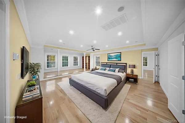 a spacious bedroom with a large bed and a flat tv screen on a dresser