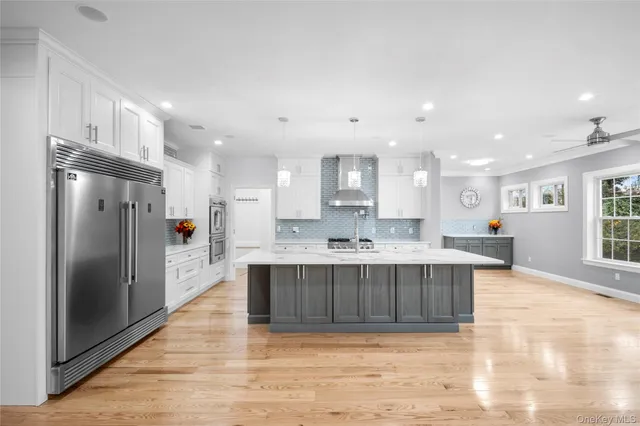 a large kitchen with kitchen island a sink stainless steel appliances and cabinets