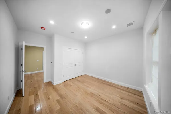 an empty room with wooden floor and entrance