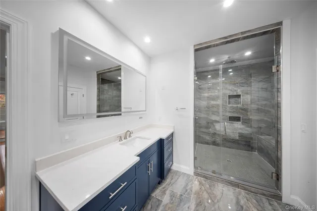 a bathroom with a shower sink and mirror