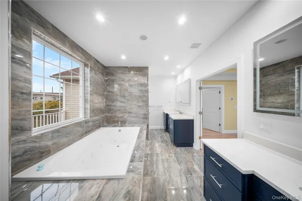 a large bathroom with a tub a sink a mirror and a shower