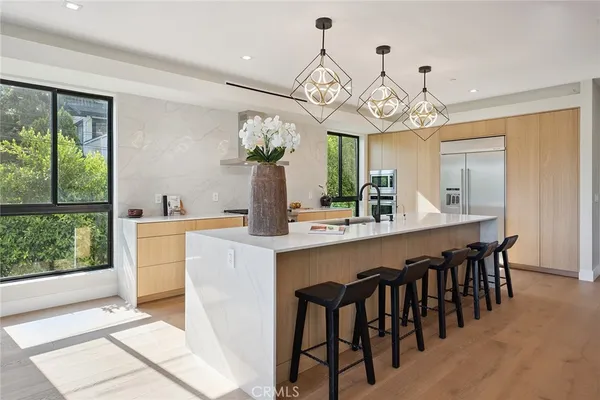 a large kitchen with a sink a counter space and wooden floor