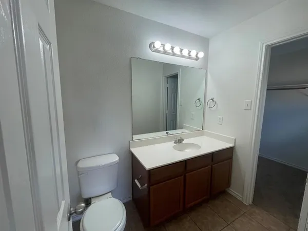 a bathroom with a toilet a sink and a mirror