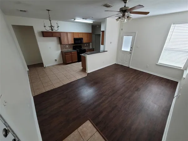 a view of a kitchen with a sink a refrigerator wooden floor and a window