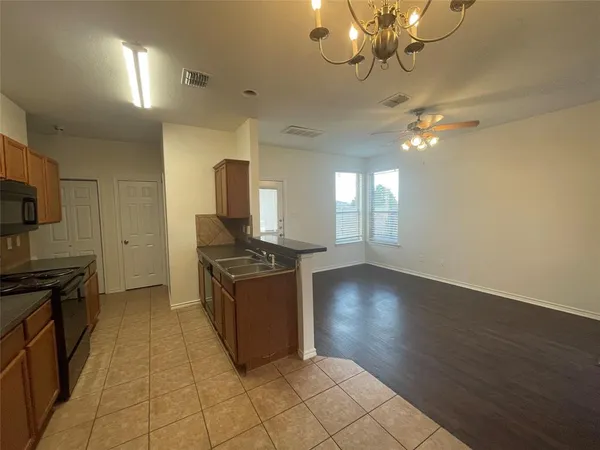 a kitchen with granite countertop a stove and a wooden floors