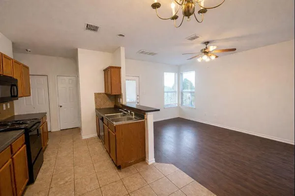 a kitchen with granite countertop a stove a sink and a refrigerator
