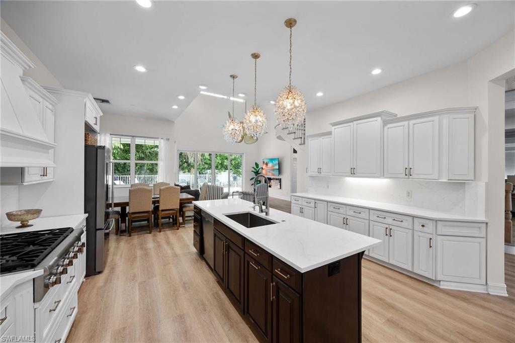 160 3rd Street North Naples, FL 34102 - Photo 15 of 48 a kitchen with granite countertop a sink stove and cabinets