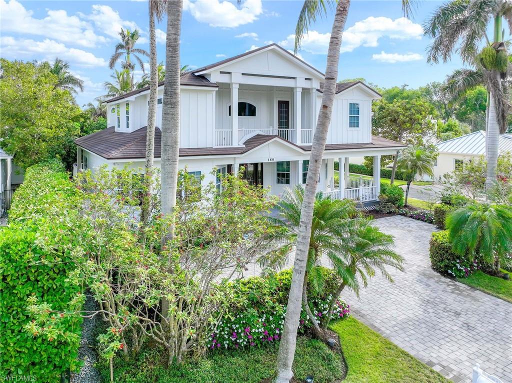 160 3rd Street North Naples, FL 34102 - Photo 2 of 48 a front view of a house with a yard and potted plants