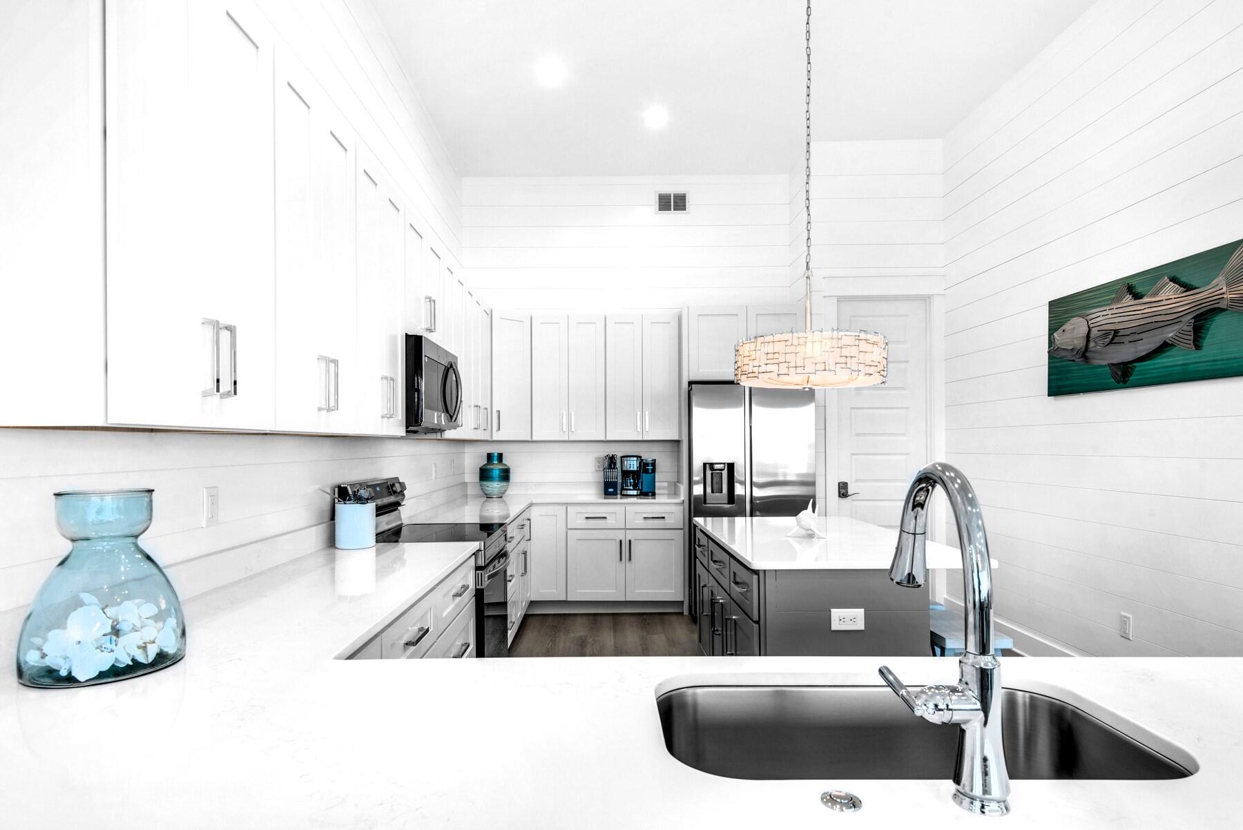 78 Cote D Azur Drive Santa Rosa Beach, FL 32459 - Photo 16 of 80 a kitchen with kitchen island granite countertop a sink a counter top space and cabinets