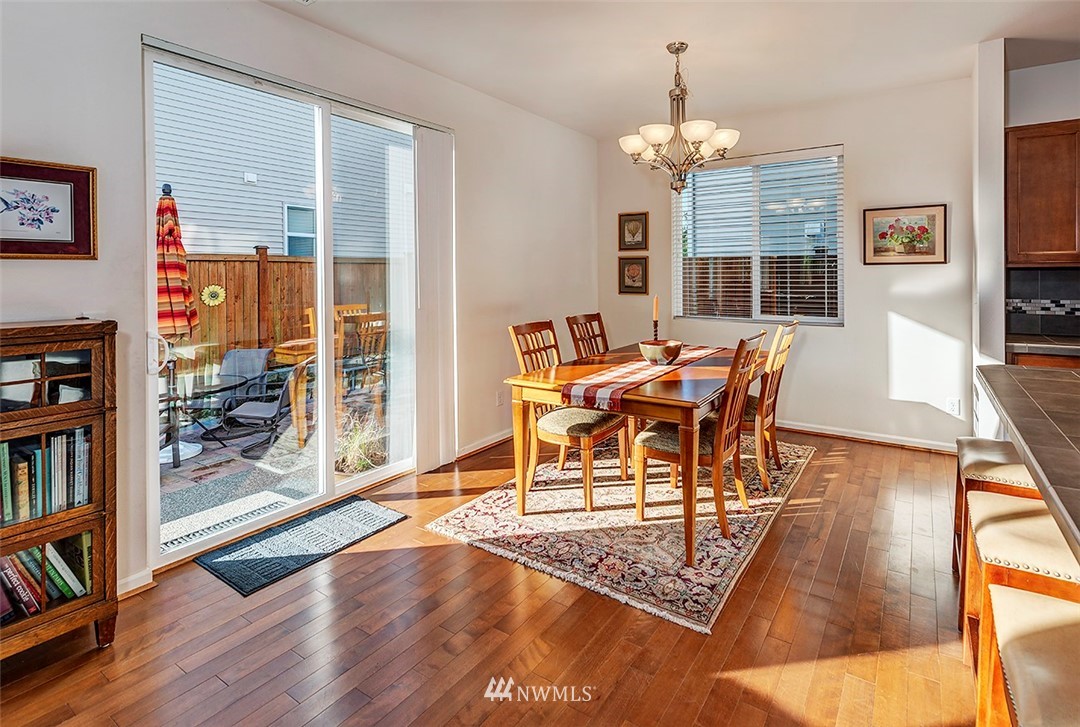 1314 124th Place Southeast Everett, WA 98208 - Photo 5 of 23 a dining room with wooden floor a chandelier a glass table and chairs