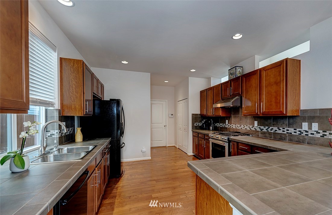 1314 124th Place Southeast Everett, WA 98208 - Photo 6 of 23 a kitchen with stainless steel appliances granite countertop a sink stove microwave and cabinets