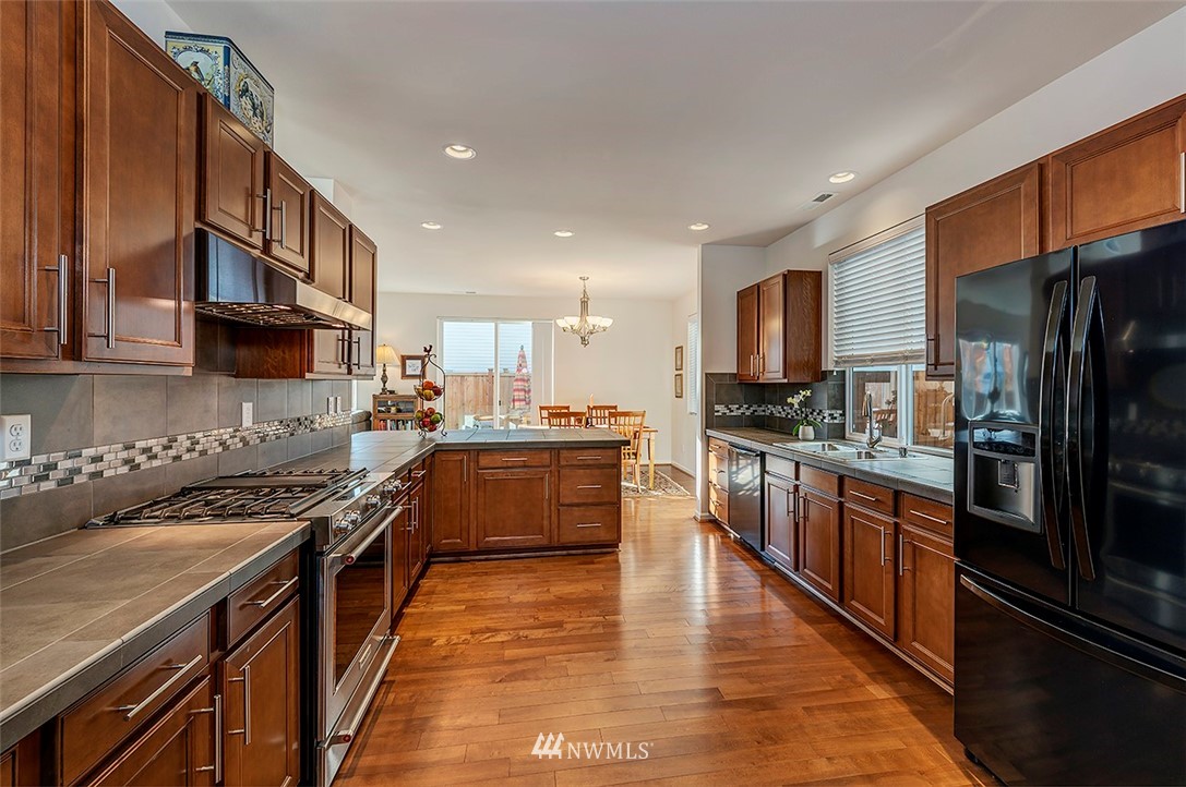 1314 124th Place Southeast Everett, WA 98208 - Photo 7 of 23 a kitchen with stainless steel appliances granite countertop a stove refrigerator sink and microwave