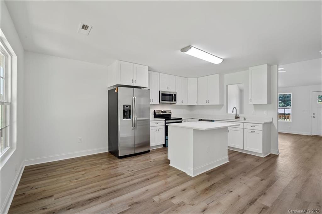 2979 Greenleaf Road, Unit 5 Clover, SC 29710 - Photo 16 of 46 a kitchen with a refrigerator cabinets and wooden floor