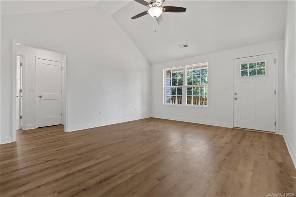 2979 Greenleaf Road, Unit 5 Clover, SC 29710 - Photo 7 of 46 an empty room with wooden floor chandelier fan and windows