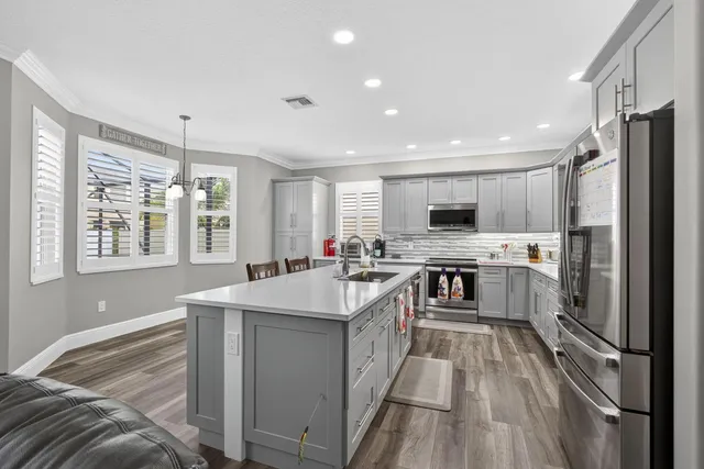 a kitchen with stainless steel appliances granite countertop a refrigerator and a stove top oven