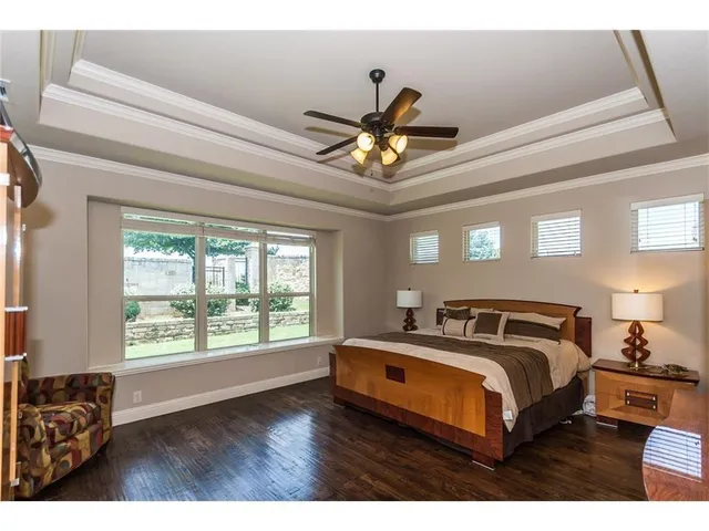 a view of a hallway with wooden floor and a chandelier fan