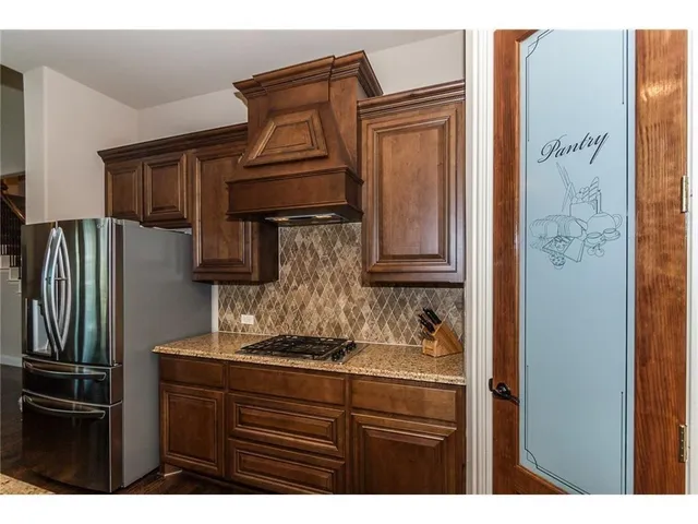 a kitchen with stainless steel appliances granite countertop a refrigerator and a stove