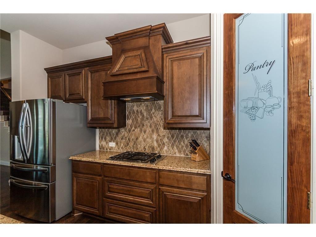 961 Crystal Falls Drive Prosper, TX 75078 - Photo 8 of 33 a kitchen with stainless steel appliances granite countertop a refrigerator and a stove