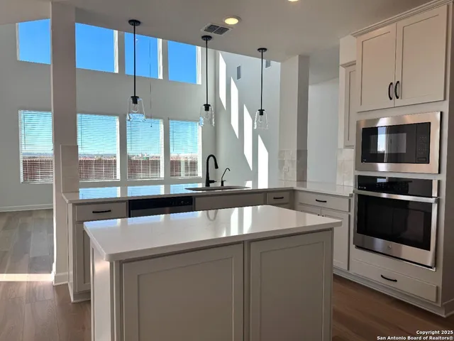 a kitchen with stainless steel appliances granite countertop a sink and a stove