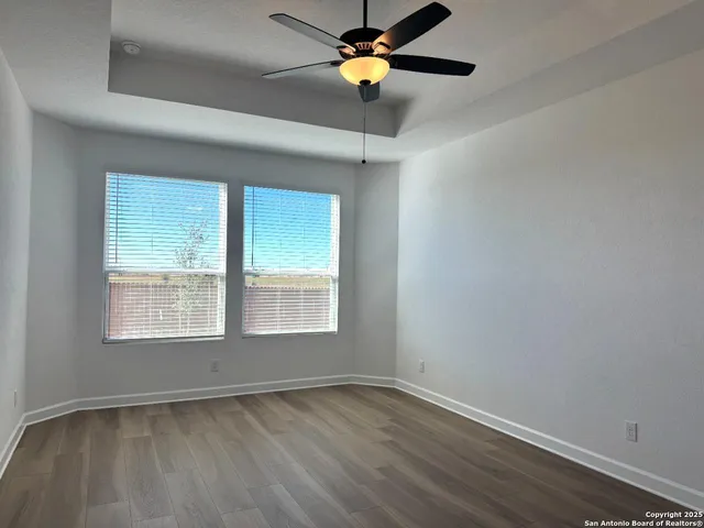 an empty room with a window and a ceiling fan