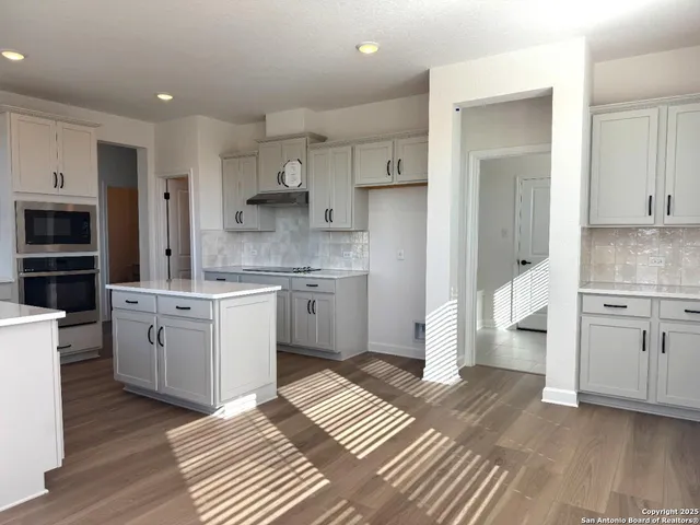 a kitchen with a white stove top oven and cabinets