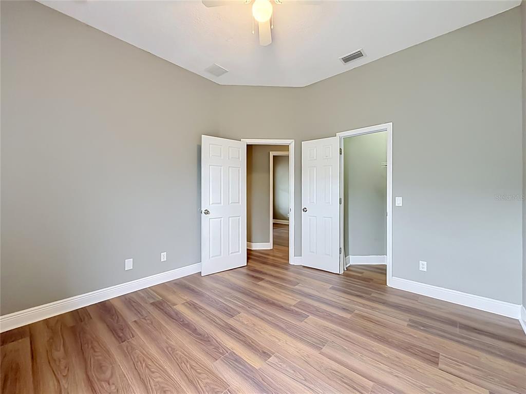 28549 Shirley Shores Road Tavares, FL 32778 - Photo 32 of 65 a view of an empty room with wooden floor and a window