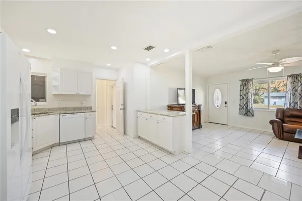 a large white kitchen with a sink and cabinets