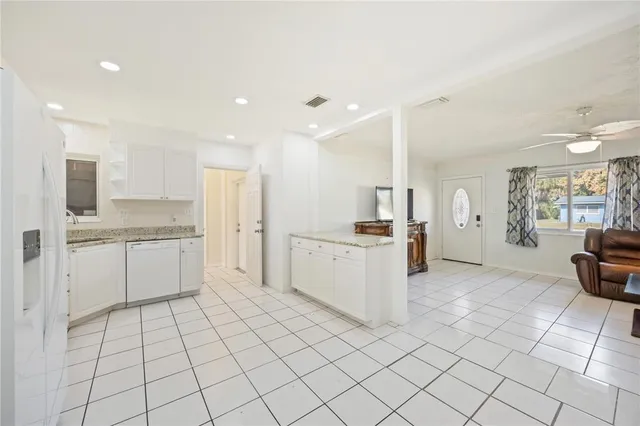 a large white kitchen with a sink and cabinets