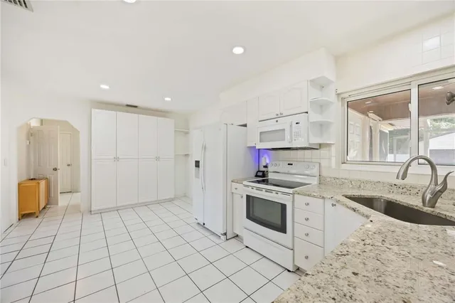 a kitchen with stainless steel appliances granite countertop a stove a sink and a refrigerator
