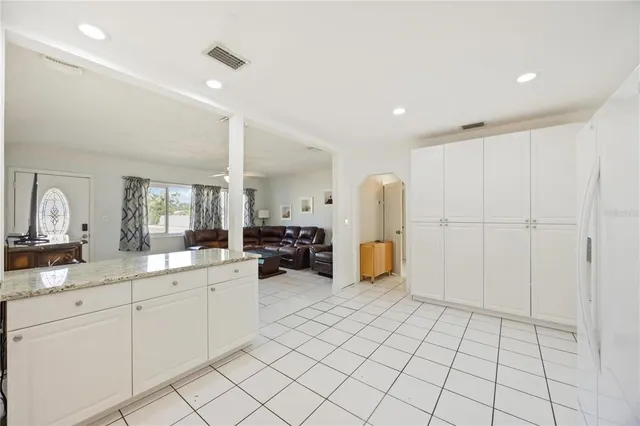 a kitchen with a sink a stove a refrigerator and white cabinets