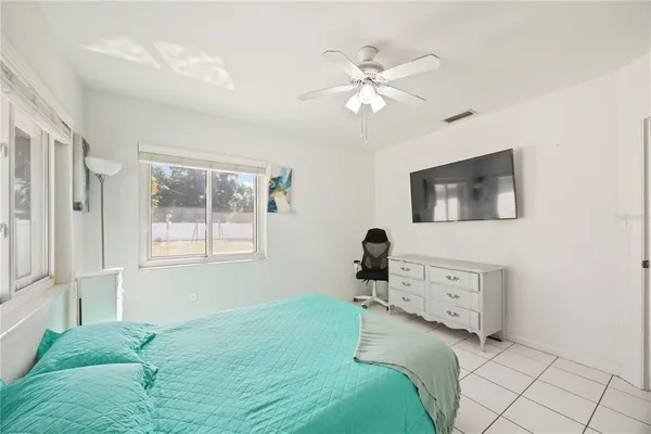 a bedroom with a bed mirror and window