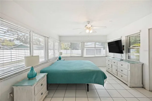 a spacious bedroom with a balcony a bed and a flat screen tv
