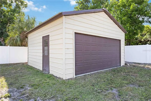 a view of small white building with a small yard
