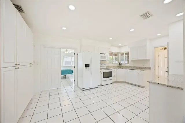 a large white kitchen with white cabinets and white appliances