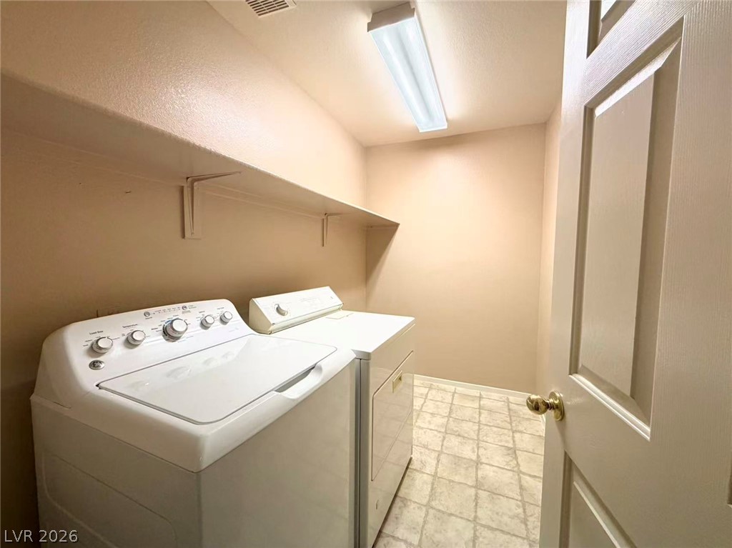 920 Hunters Ridge Way North Las Vegas, NV 89032 - Photo 14 of 16 Functional laundry room features overhead shelving and durable vinyl flooring.