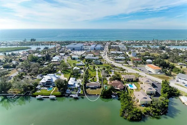 an aerial view of a city with lots of residential buildings ocean and mountain view in back