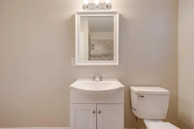 a bathroom with a toilet sink and mirror